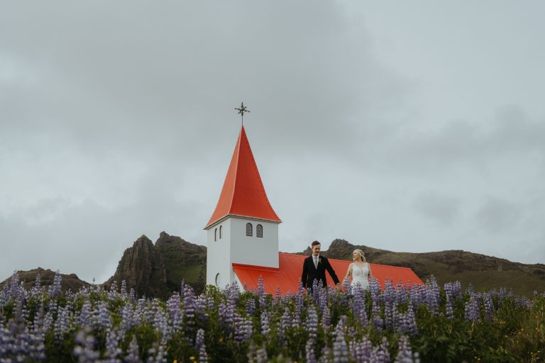 Couple embracing on the dramatic south coast of Iceland during their elopement